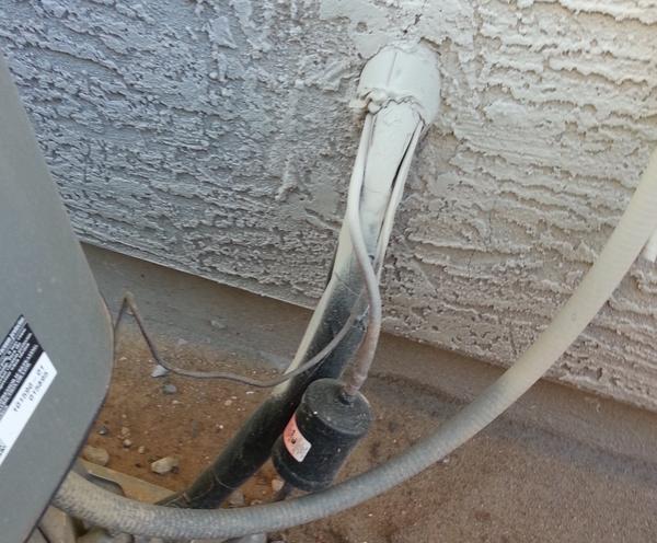 Closeup of a refrigerant line going from the outdoor unit into a home.