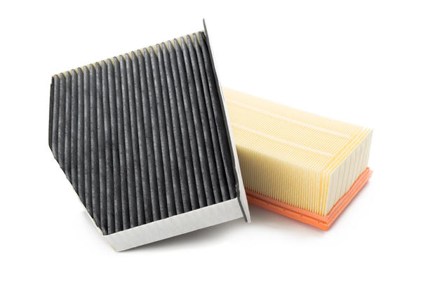 Two air filters stacked on top of one another against an all white background.