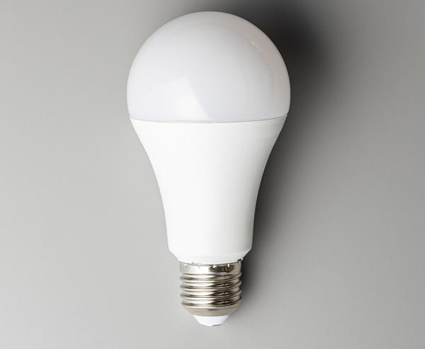 A single LED lightbulb laying against a light gray background