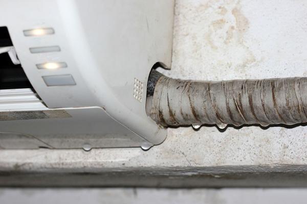 Closeup of the bottom of a ductless AC unit that is leaking water
