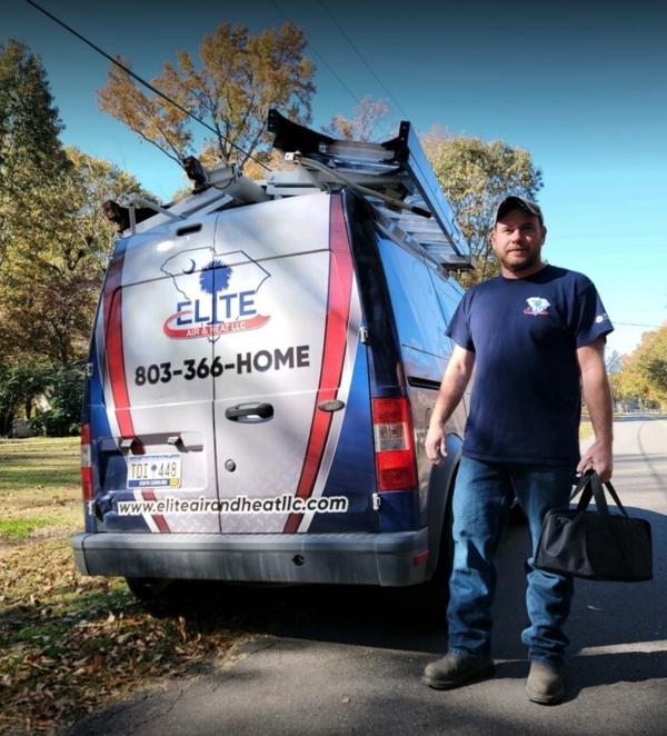 Elite Air tech standing in front of work van