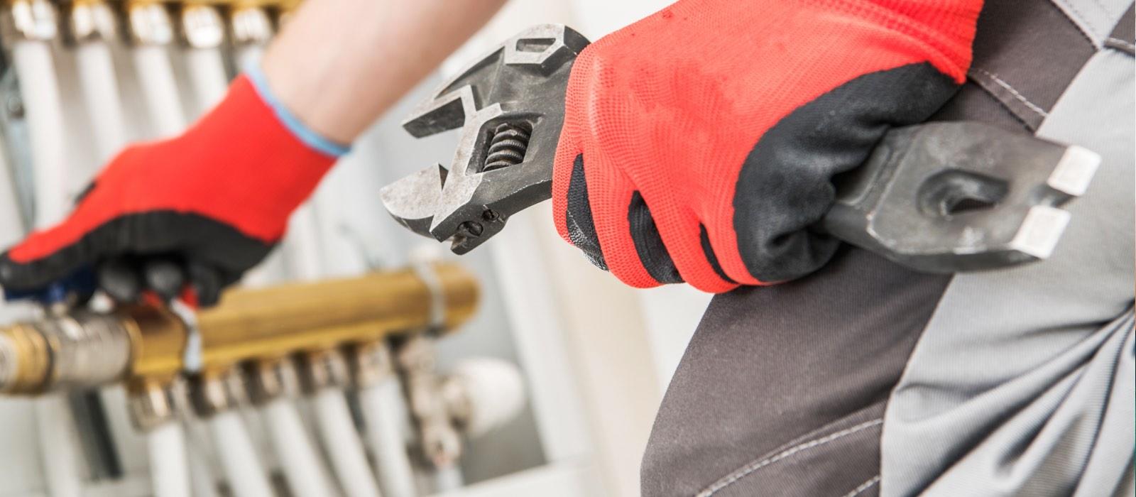 Closeup of gloved hand holding wrench and adjusting tubes