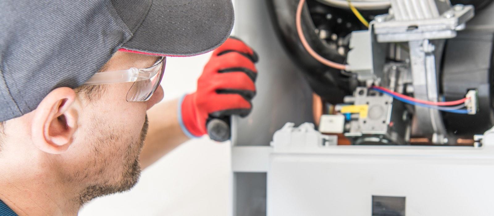 Male technician visually inspecting heating equipment