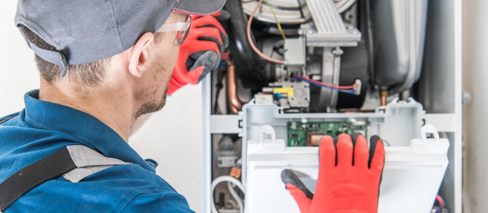Technician with red gloves examines complex machinery